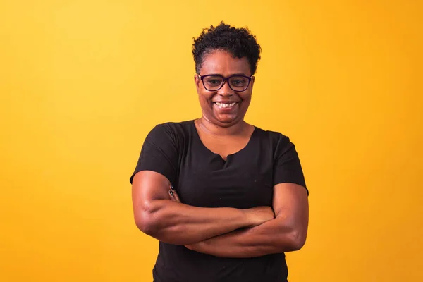 stock image mature woman wearing prescription glasses. black woman with glasses with cross arms