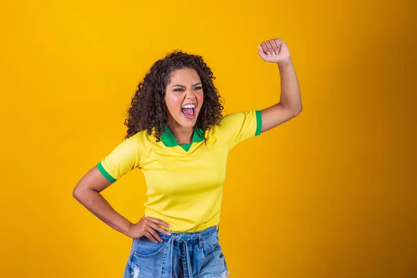 ブラジルのサポーター サッカーを祝うブラジルの巻き毛の女性のファン 黄色の背景にサッカーの試合 ブラジル色 — ストック写真