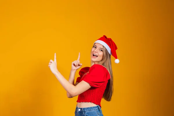 Close Photo Positive Girl Santa Claus Hat Pointing Forefinger Copyspace — стоковое фото