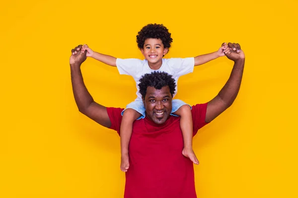 黄色の背景に父とアフロの息子の笑顔と演奏 父の日のコンセプト — ストック写真
