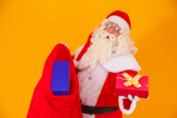 Skutečný Santa Claus Žlutém Pozadí Držení Taška Různými Vánoční Dárky — Stock fotografie
