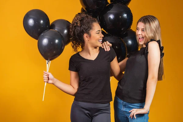 Twee Vriendinnen Gele Achtergrond Met Zwarte Ballonnen Zwarte Vrijdag Promotie — Stockfoto