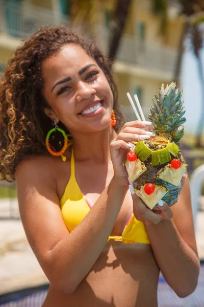 休暇中の若い女性がパイナップルドリンクを飲み — ストック写真
