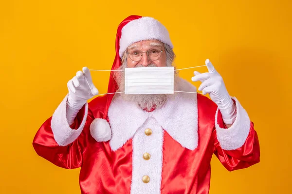 Real Santa Claus Yellow Background Holding Protective Mask Glasses Hat — Stock Photo, Image