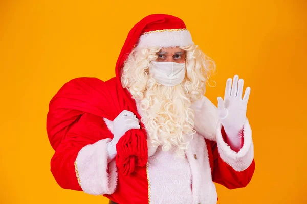 真正的圣诞老人 背景是黄色的 戴着防护面具 遮挡着棺材 有社交距离的圣诞节 Covid — 图库照片