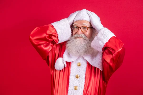 Forgotten Santa Claus on red background. Santa Claus with his hand on his head like he\'s forgotten something. Do not remember