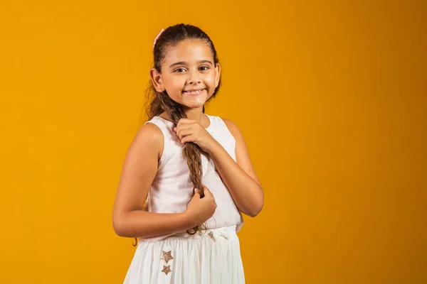 長い健康な波状の髪の女の子 美しさ 黄色の背景にかわいい顔で笑顔の子モデル 幸せな子供 子供時代の概念 — ストック写真