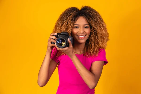 Genç Afro Fotoğrafçı Elinde Sarı Arka Planda Bir Kamera Tutuyor — Stok fotoğraf