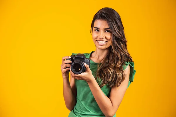 Sarı Arka Planda Fotoğraf Makinesi Tutan Genç Bir Kız Kadın — Stok fotoğraf
