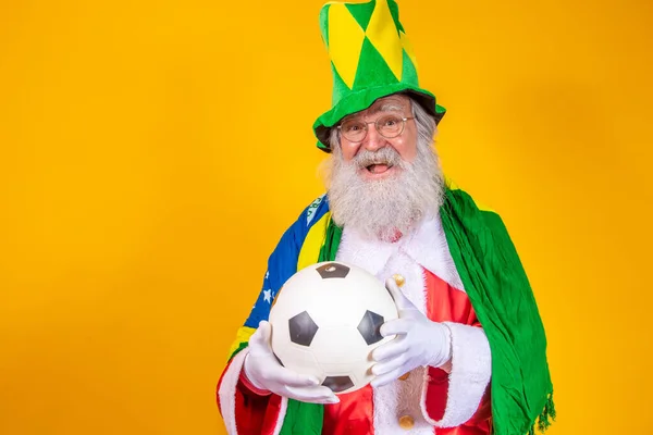 サンタクロースはブラジルのファンです サンタ クラウス ブラジル代表のサポーター スポーツ選手権 ブラジルの旗とボールを持つサンタクロース サッカー試合 — ストック写真