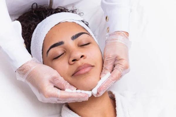 美容师用棉花清洁女人的脸 水疗中心的妇女洗脸 — 图库照片