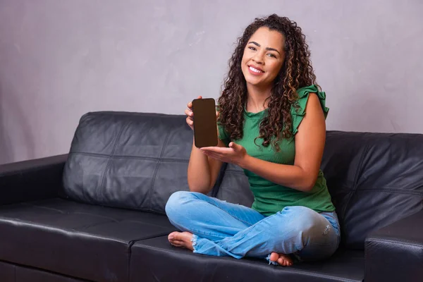 Kanepede Oturan Afro Kadın Elinde Beyaz Ekranlı Cep Telefonu Mesaj — Stok fotoğraf
