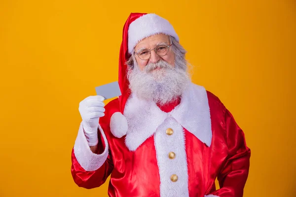Foto Santa Claus Sosteniendo Una Tarjeta Crédito Sobre Fondo Amarillo —  Fotos de Stock