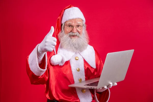 Άγιος Βασίλης Χρησιμοποιώντας Ένα Φορητό Υπολογιστή Κόκκινο Φόντο — Φωτογραφία Αρχείου
