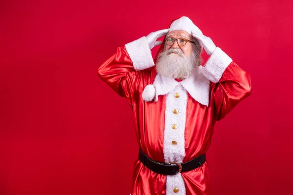 Forgotten Santa Claus on red background. Santa Claus with his hand on his head like he\'s forgotten something. Do not remember