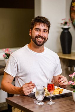 Yakışıklı adam salgın sırasında restoranda tek başına yemek yiyor.