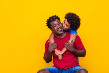 Oğul babasının yanağına öpücük konduruyor. Babalar Günü.