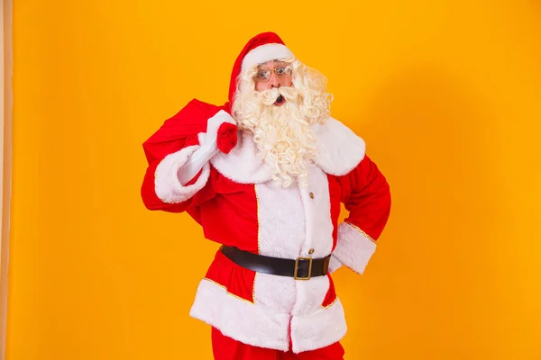 Der Weihnachtsmann Auf Gelbem Hintergrund Hält Eine Tüte Mit Geschenken — Stockfoto