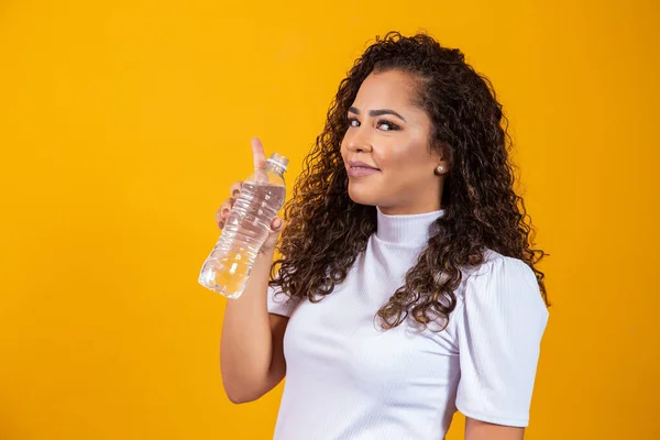 健康的な若い女性は黄色の背景に水を飲むテキストのためのスペース — ストック写真