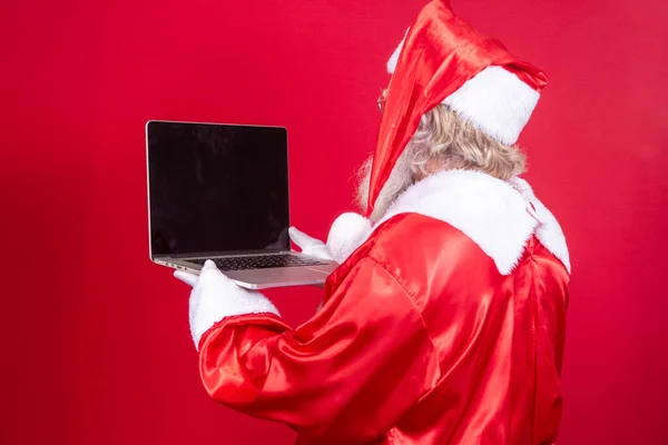 Santa Claus Using Laptop Red Background His Back Turned — Stock Photo, Image