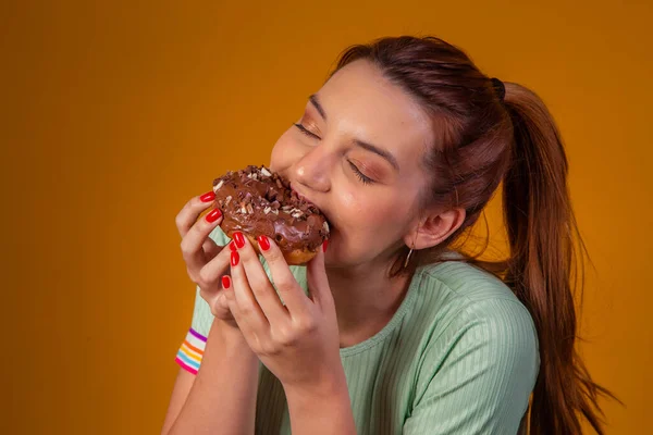 年轻的红头发女人吃美味的巧克力甜甜圈 年轻人吃着美味的甜甜圈 — 图库照片