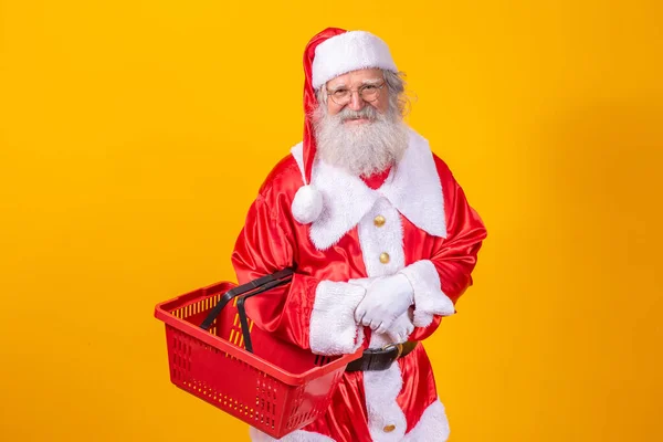 Der Weihnachtsmann Hält Einen Leeren Einkaufskorb Und Blickt Lächelnd Die — Stockfoto