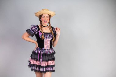 Sarışın Brezilyalı kadın, Haziran partisi kıyafetleri, atari tarzı. Eller kalçada..