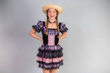 Sarışın Brezilyalı kadın, Haziran partisi kıyafetleri, atari tarzı. Eller kalçada..