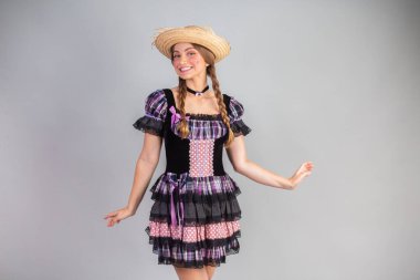 Sarışın Brezilyalı kadın, Haziran partisi kıyafetleri, atari tarzı. Eller kalçada..