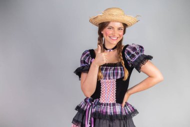 Sarışın Brezilyalı kadın, Haziran partisi kıyafetleri, atari tarzı. Başparmaklar yukarı.