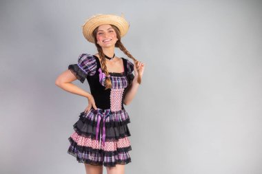 Sarışın Brezilyalı kadın, Haziran partisi kıyafetleri, atari tarzı. Eller kalçada..