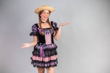 Sarışın Brezilyalı kadın, Haziran partisi kıyafetleri, atari tarzı. Kollarını aç..