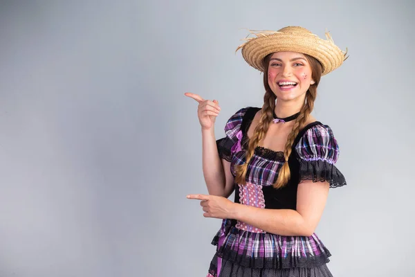 stock image Blonde Brazilian woman, June party clothes, arraial. showing an ad on the side, advertising space.