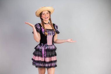 Sarışın Brezilyalı kadın, Haziran partisi kıyafetleri, atari tarzı. Kollarını aç..