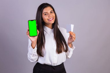 Elinde akıllı telefon olan Brezilyalı bir kadın. Yeşil ekran. ve kredi kartları.