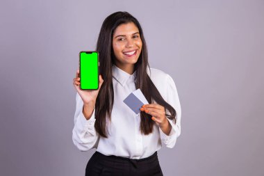 Elinde akıllı telefon olan Brezilyalı bir kadın. Yeşil ekran. ve kredi kartları.