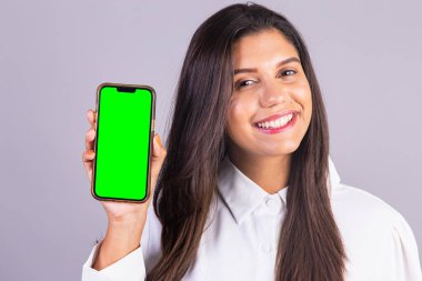 Elinde akıllı telefon olan Brezilyalı bir kadın. yeşil ekran.