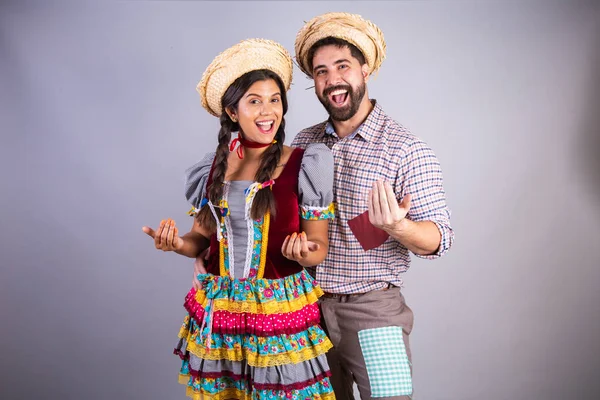 stock image brazilian couple, clothes from festa junina, arraial, festa de so joo. boyfriend and girlfriend. inviting hands