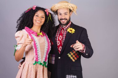 Festa Junina, Arraial, Festa de So Joo 'nun tipik kıyafetlerini giyen çift. Kamerayı işaret ediyor.. 