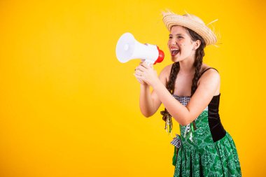 Kız, Brezilyalı, Festa Junina, Arraial, Festa de So Joo kıyafetleriyle. Yatay portre. Megafonla, reklam promosyonuyla. 