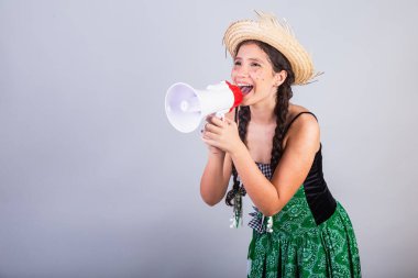 Kız, Brezilyalı, Festa Junina, Arraial, Festa de So Joo kıyafetleriyle. Yatay portre. Megafonla, reklam promosyonuyla. 
