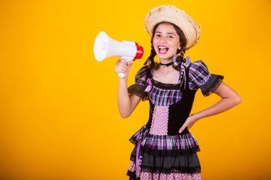 Kız, Brezilyalı, Festa Junina, Arraial, Festa de So Joao kıyafetleriyle. Yatay portre. Megafonla, reklam promosyonuyla.
