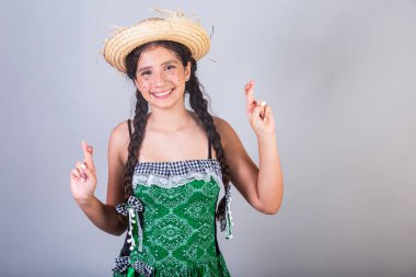Kız, Brezilyalı, Festa Junina, Arraial, Festa de So Joao kıyafetleriyle. Yatay portre. Parmaklar çapraz, dilek, umut.