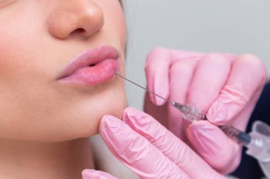 Güzellik kliniğinde bornoz giyen kadın estetik, hasta, estetik ameliyatlar. Hyaluronik asit uygulaması. Dudaklarından..