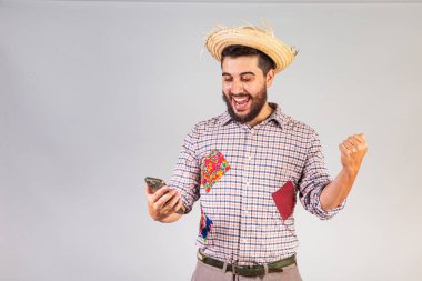 Brezilya 'lı bir adam şenlik Junina kıyafetleri giyiyor. Arraial, Aziz John bayramı. Akıllı telefonla, bakınarak. mobil uygulamalar.