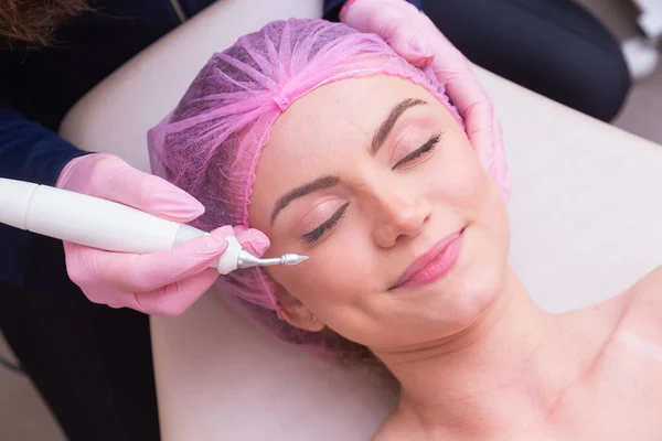 closeup photo of woman's face, photo of aesthetics, anti aging procedures. Plasma jet application. Aesthetics, spa. beautician.