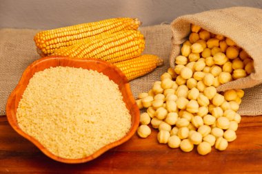 Mısır koçanı, mısır gevreği ve mısır gevreği, ahşap bir arka planda paketlenmiş.