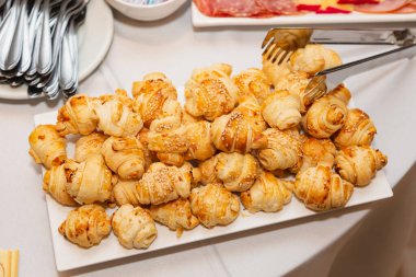 Beyaz tabak, mini kruvasan, aperatifler ve parti atıştırmalıkları..