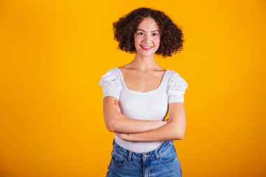 Beyaz gömlekli, mavi kotlu, kollarını kavuşturmuş beyaz bir model..