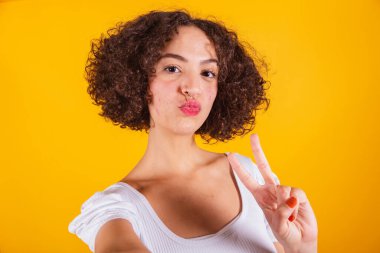 Beyaz gömlekli, kot pantolonlu, selfie, barış ve aşkla dolu beyaz bir model. Öpücük gönder.